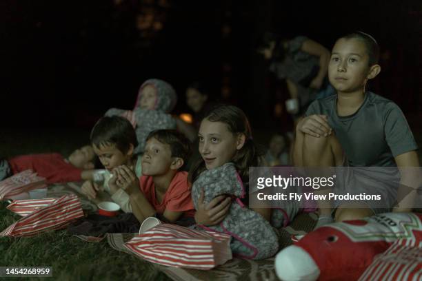 kids watching movie on outdoors projector screen - backyard movie stock pictures, royalty-free photos & images