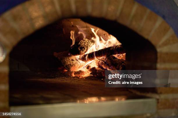 wood-fired oven made of brick for pizzas in a gourmet restaurant, without people, with the ember lit, side view - smelting stock pictures, royalty-free photos & images