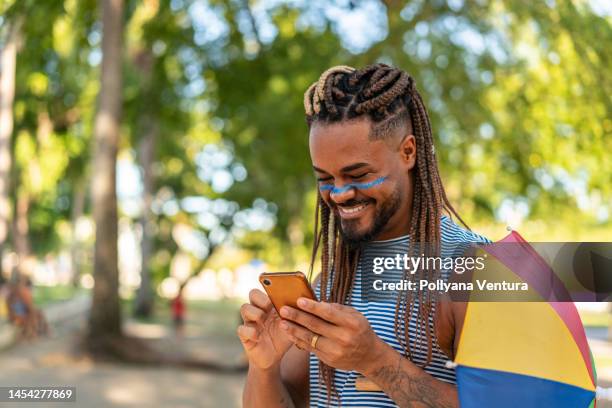 man using smartphone at brazilian carnaval - fiesta of san fermin stockfoto's en -beelden