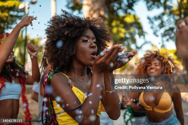 blowing confetti at the brazilian carnaval - fiesta of san fermin stockfoto's en -beelden