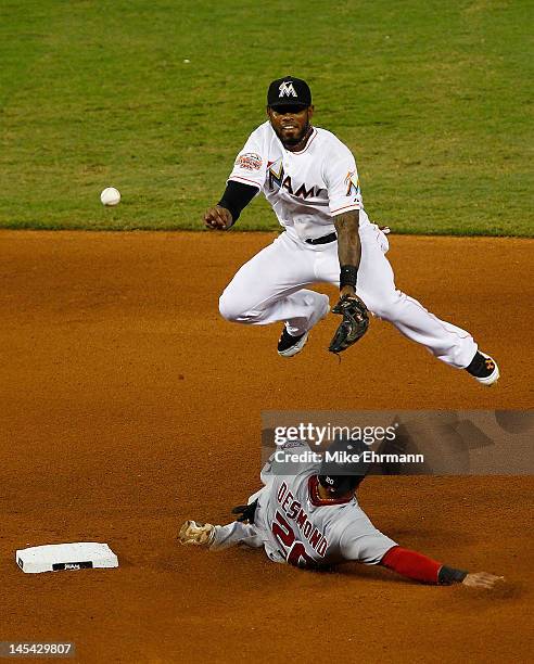 Jose Reyes of the Miami Marlins turns a double play as Ian Desmond of the Washington Nationals slides into second during a game at Marlins Park on...