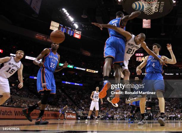 Tim Duncan of the San Antonio Spurs looses the ball as he goes up for a shot against Serge Ibaka and Nick Collison of the Oklahoma City Thunder in...