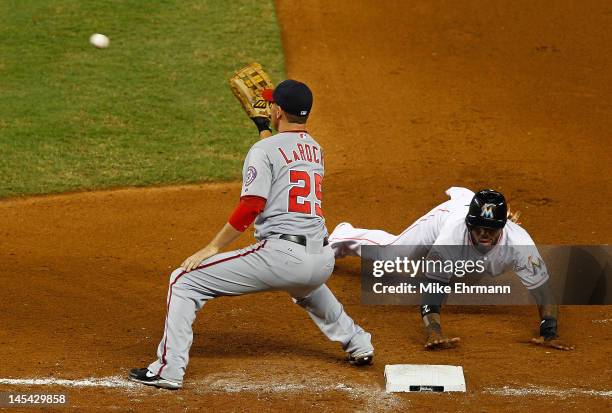 Jose Reyes of the Miami Marlins dives back to first as Adam LaRoche of the Washington Nationals catches the throw during a game at Marlins Park on...