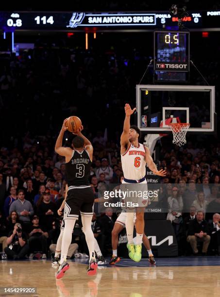 Keldon Johnson of the San Antonio Spurs takes a shot as Quentin Grimes of the New York Knicks defends in the final second of the game at Madison...