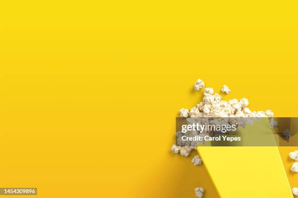 pop corn bowl in yellow - movie explosion stockfoto's en -beelden