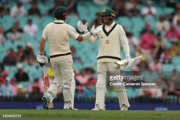 Travis Head of Australia celebrates reaching his half century with Usman Khawaja of Australia during day two of the Second Test match in the series...
