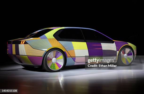 The color-changing ability of the BMW i Vision Dee concept EV sport sedan is demonstrated during a keynote address by Chairman of the Board of...