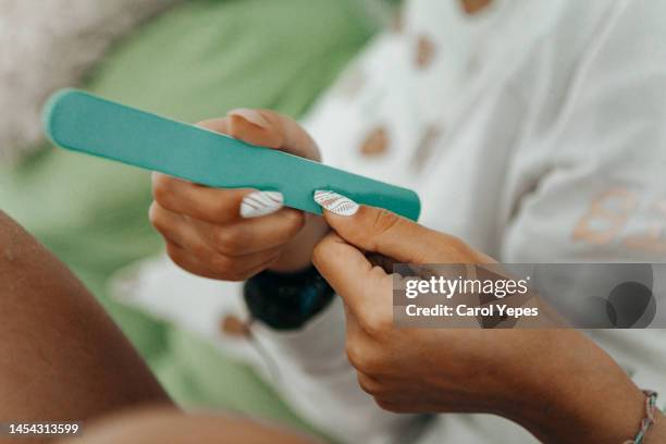 female doing nail polishing - nagelfeile stock-fotos und bilder