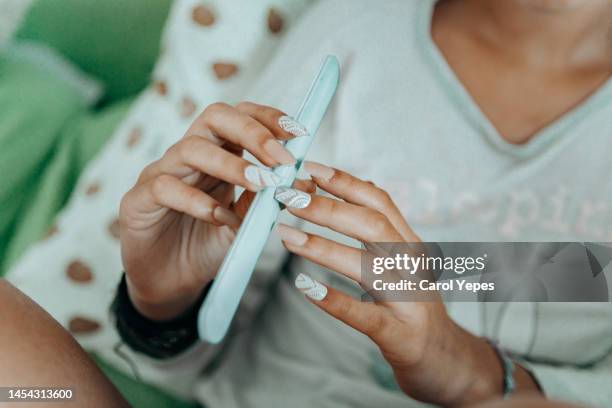 close up of woman with long, slender finger spolishing - long fingernails imagens e fotografias de stock