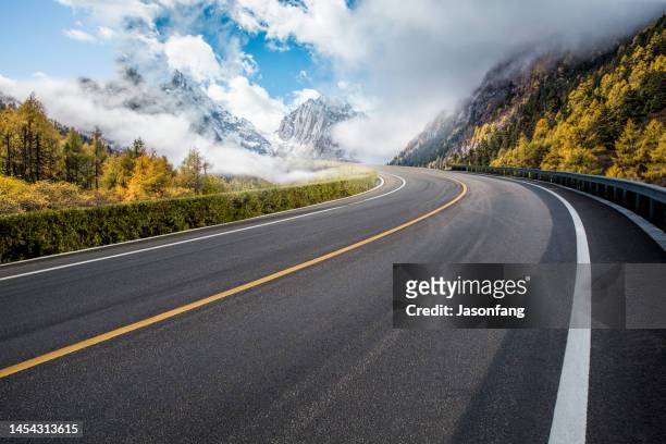 strada di montagna in autunno - strada foto e immagini stock