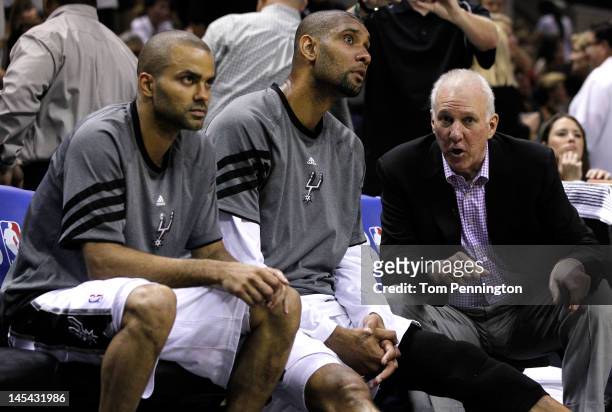 Head coach Gregg Popovich of the San Antonio Spurs talks to Tim Duncan and Tony Parker on the bench in the third quarter while taking on the Oklahoma...
