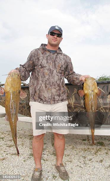 Chris Conrade holds two flathead catfish he caught at El Dorado Reservoir in Kansas, using Topcat sets.