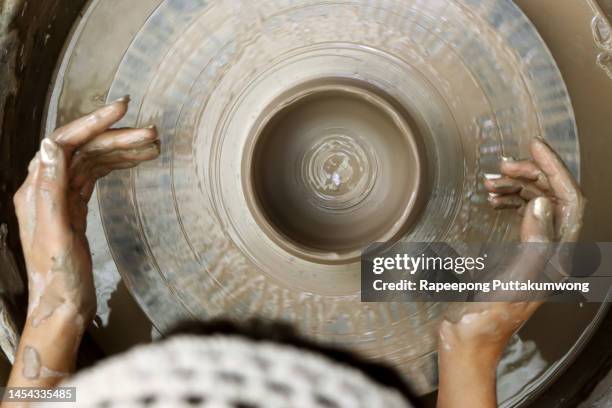 women working on the potter's wheel. hands sculpts a cup from clay pot. workshop on modeling on the potter's wheel - pottery wheel photos et images de collection