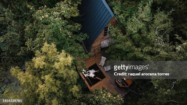 drone view of a couple in a wooden cabin - cottage ストックフォトと画像