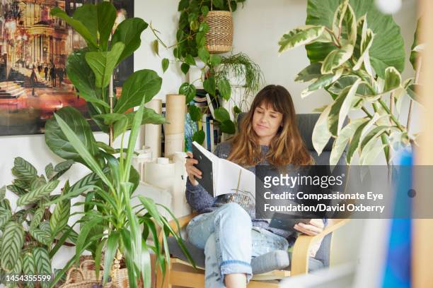 mature artist working in her studio - brown hair with highlights stock pictures, royalty-free photos & images