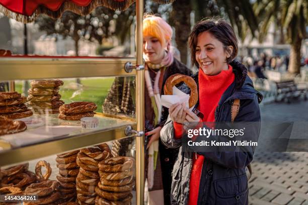 young tourists buying traditional street food in istanbul,simit - turkish bagel stock pictures, royalty-free photos & images