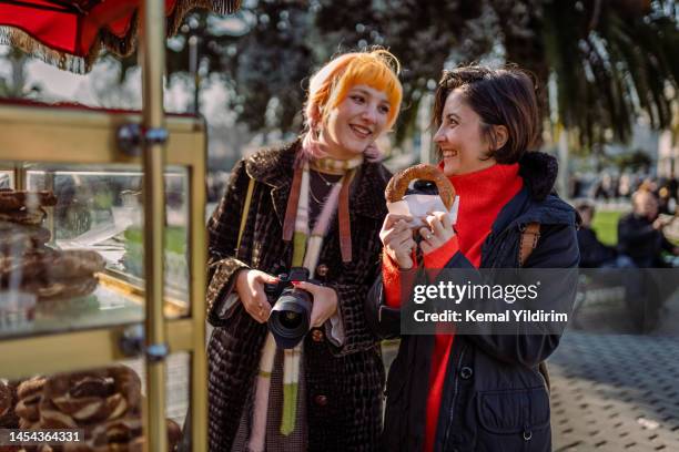 young tourists buying traditional street food in istanbul,simit - turkish bagel stock pictures, royalty-free photos & images