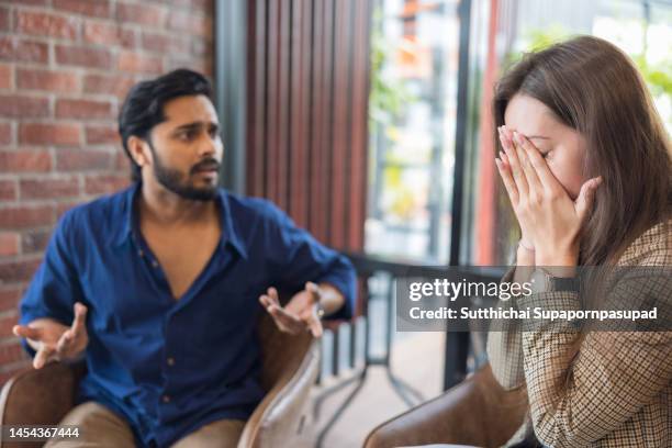 young couple arguing while having problems in their relationship. - conflict stockfoto's en -beelden