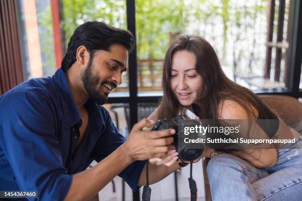 young couple looking the digital camera together. - appareil photo numérique photos et images de collection