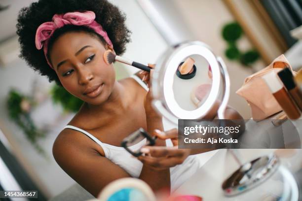 beautiful young woman applying blusher. - applying makeup stock pictures, royalty-free photos & images