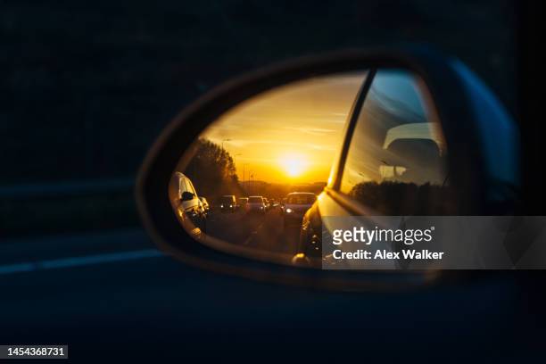 highway traffic in vehicle side mirror at sunset. - motorway roadworks stock pictures, royalty-free photos & images