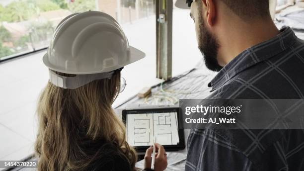 two engineers discussing building drawing on digital tablet at site - close up of blueprints stock pictures, royalty-free photos & images