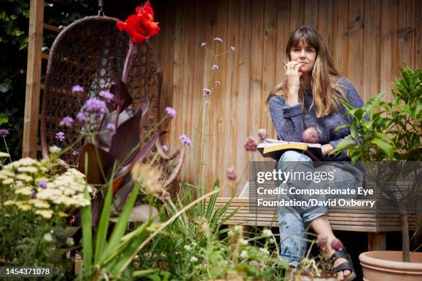 portrait of artist in studio garden - legs crossed at knee stock pictures, royalty-free photos & images