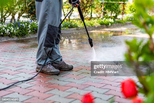 hombre mayor en casa limpiando el patio con lavadora de alta presión - hacer la colada fotografías e imágenes de stock