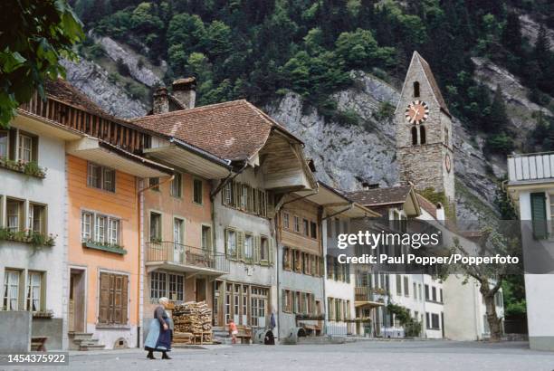 Resident walks across Obere Gasse in the old town district of the town of Interlaken in the canton of Bern in central Switzerland circa 1960. Visible...