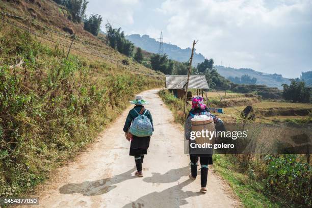 two indigenous woman from black hmong minority walking in sa pa highlands - hmong stockfoto's en -beelden