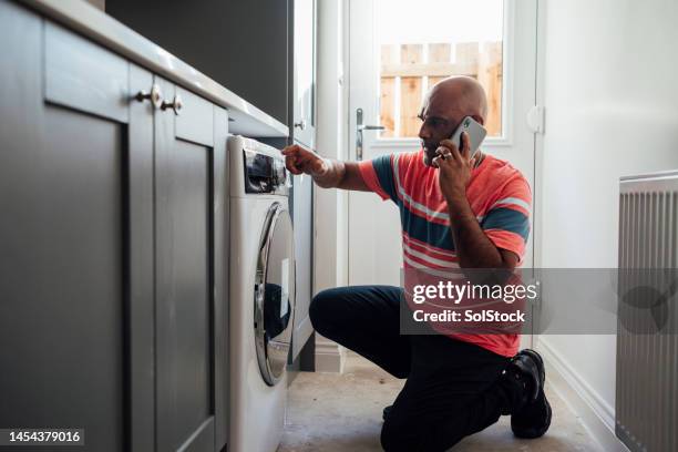 calling appliance repair service - tvättmaskin bildbanksfoton och bilder
