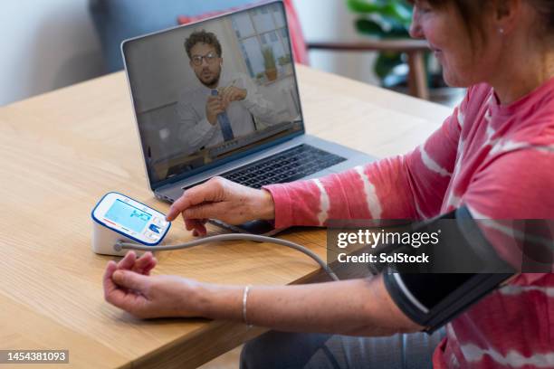 checking her blood pressure with a doctor - screening of at t audience networks mr mercedes arrivals stockfoto's en -beelden