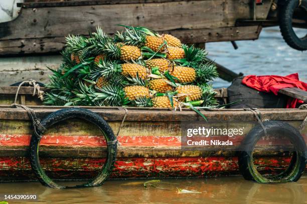 pineapples in a boat for sale, mekong delta, vietnam - can tho province stock pictures, royalty-free photos & images