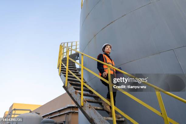 a female engineer works in a chemical plant - chemical plants stock pictures, royalty-free photos & images