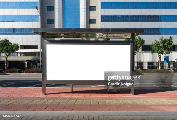 blank billboard at city bus stop - billboard bus stockfoto's en -beelden