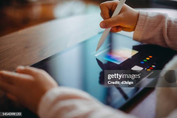 close up of a little girl drawing on digital tablet using a digitized pen at home. creative learning. children's engagement of digital technology - interactivity illustration stock pictures, royalty-free photos & images