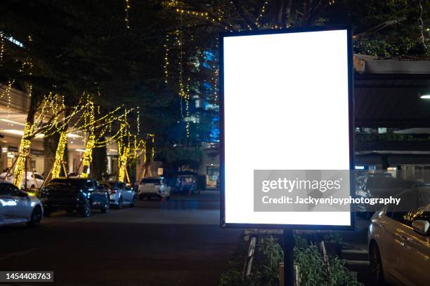 blank billboard on city street at night. outdoor advertising - advisory board stockfoto's en -beelden