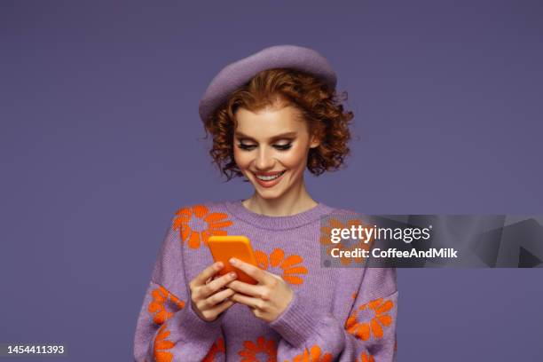 hermosa mujer emocional usando teléfono inteligente - sombrero púrpura fotografías e imágenes de stock