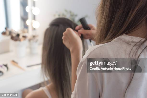 hairdresser combing, cutting and straightening the client's hair. hairdressing session. - quarantine wedding stock pictures, royalty-free photos & images