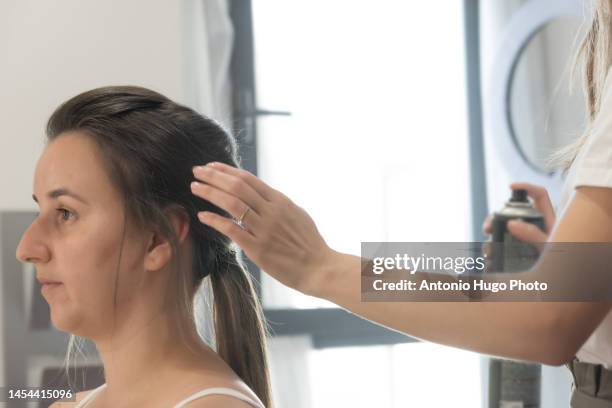 hairdresser spraying hairspray on the client's hair. hairdressing session. - quarantine wedding stock pictures, royalty-free photos & images