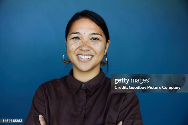 young businesswoman smiling in front of a blue background - fundo colorido imagens e fotografias de stock