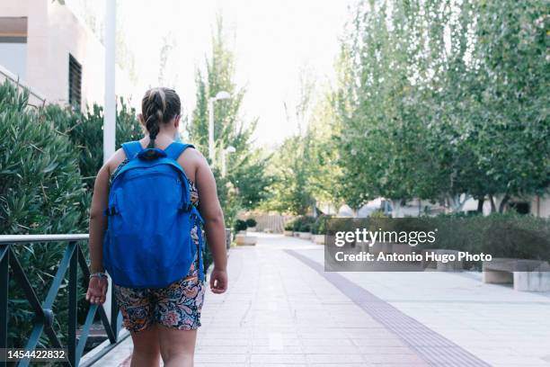 blonde girl with blue backpack on her way to school - child obesity stock pictures, royalty-free photos & images