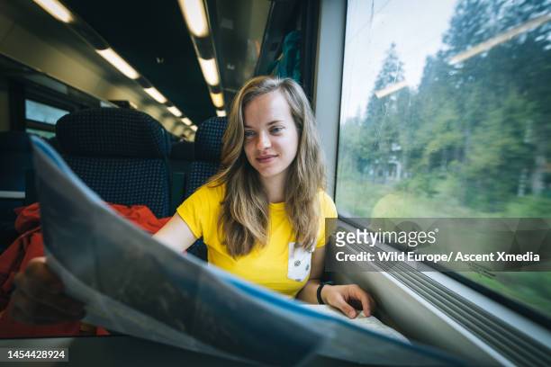 young woman looks at map on train - selective focus foto e immagini stock