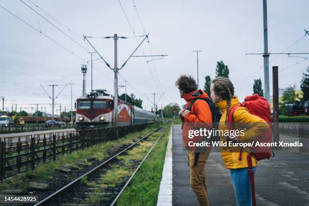 backpackers wait for train at station in countryside - escape rom stock pictures, royalty-free photos & images