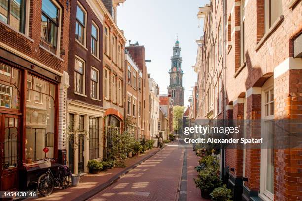 amsterdam street and westerkerk church, holland, netherlands - amsterdam foto e immagini stock