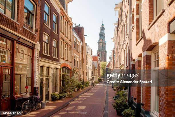 amsterdam street and westerkerk church, holland, netherlands - amsterdam stock pictures, royalty-free photos & images