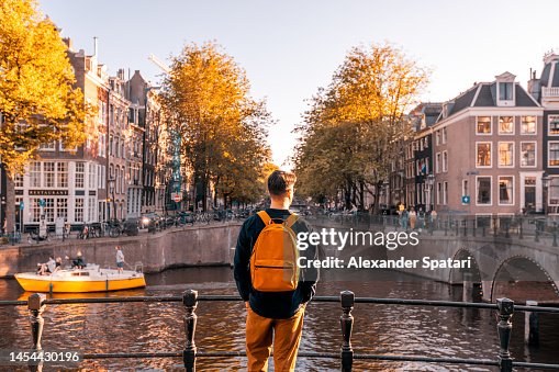 Rear view of a man looking at Amsterdam canal on a sunny day, Netherlands Rear view of a man looking at Amsterdam canal on a sunny day, Netherlands