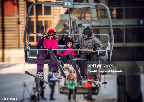 excited child on ski lift with parents - couple ski lift stockfoto's en -beelden