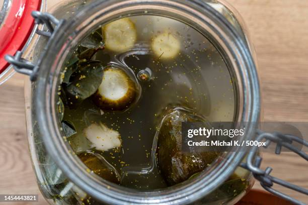 pickled cucumbers with horseradish and garlic in a large glass jar,a traditional polish dish,warsaw,poland - large cucumber stockfoto's en -beelden