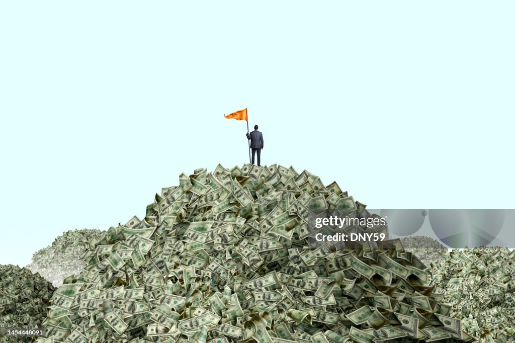 Homem plantando bandeira em pilhas de dinheiro